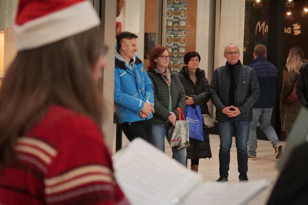 FOTO in VIDEO: Božične pesmi zazvenele sredi nakupovalnega vrveža