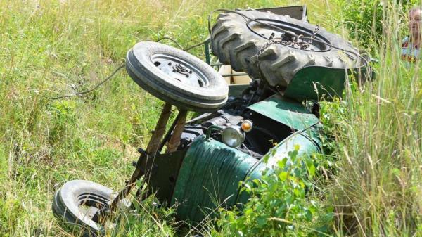 Traktor zdrsnil po pobočju in se prevrnil, voznik poškodovan